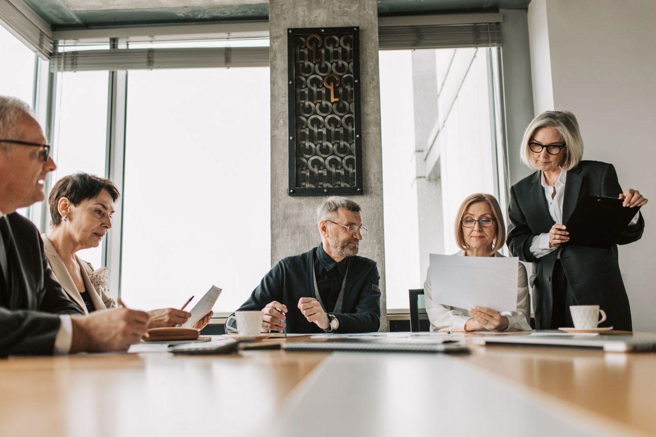 A leadership team going through documents at a table in a bright meeting room