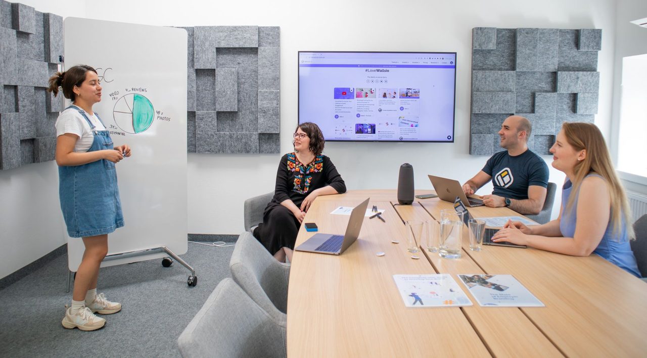 A marketing team reviewing a presentation on screen in a modern meeting room